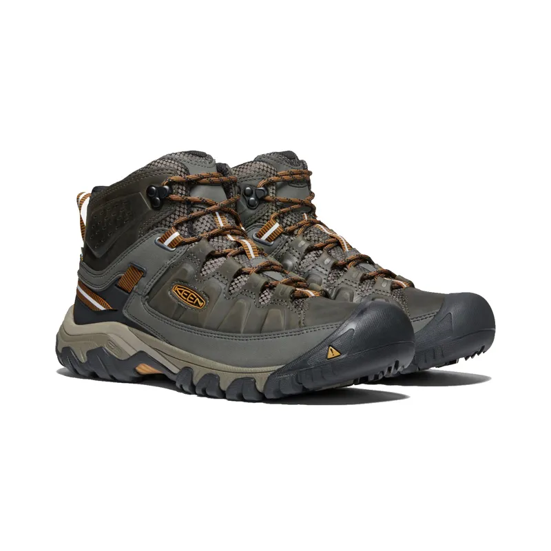 Men's Brown and Gray Merrell Hiking Shoes Holding Stick · Free Stock Photo